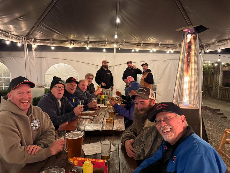 Club members gathered around a campfire after a long ride